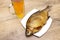 Smoked bream and a glass of light beer on a wooden table