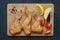 Smoked chicken wings on a wooden chopping Board with vegetables. Dark background