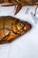 Smoked freshwater common bream fish for home use on white paper
