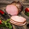 Smoked ham on a chopping board. Cutted Ham Sausage on wooden background