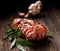 Smoked ham on a wooden rustic table with addition of fresh aromatic herbs