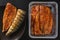 Smoked marinated mackerel fillet or fillet herring fish with spices packed in box on plate over slate stone background.