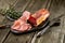 Smoked meat on wooden board with rosemary fork knife cuisine wooden texture