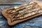 Smoked oceanic saury on wooden cutting board, top view, copy space