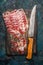 Smoked pork meat from coppa with kitchen knife on rustic wooden background. Traditional Italian specialty made from pork neck