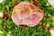 Smoked and presliced pork ham decorated with fresh radish