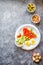 Smoked red fish salmon with olive, quail eggs, nuts and rice crispy cakes with avocado on a gray background. Top view. Rustic.