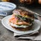 Smoked salmon bagels sandwich with soft cheese and micro greens on a cutting board