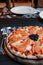 Smoked Salmon italian pizza with black Caviar close up shot