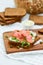 Smoked salmon sandwich with cheese, pistachio and salad leaves, brown breads