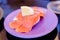 Smoked Salmon sushi with lemon on purple dish.