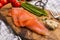 Smoked salmon on a wooden board with chive, tomato, horseradish and fork