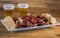 Smoked sausage with bread and onions and glasses of beer on wood background. Snack appetizer calabrese sausage with onion