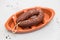 Smoked sausage chourico on brown ceramic dish