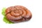 Smoked sausage twisted in a spiral and bound with a beechnut, isolated on a white background.