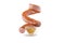 A smoked sausage, twisted in a spiral, levitates over a mustard sauce isolated on a white background