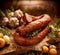 Smoked sausage on a wooden rustic table with addition of fresh aromatic herbs and spices, natural product from organic farm