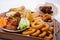 Smoked snacks for beer on wooden board, flat lay. Top view on assortment of unhealthy smoked dining.