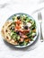 Smoked trout greek salad on a light background, top view. Healthy mediterranean diet food