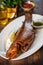 Smoked trout served with sauce, lemon on a white plate