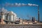 A Smokestack Emits Smoke - The Clear Blue Sky In The Background