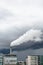 A smokestack emitting white fumes against a stormy sky