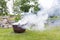 Smoking cauldron in a garden in summer