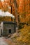 Smoking Chimney house in forest. Landscape with Little house in Autumn forest.