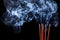 Smoking incense sticks on black background