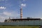 Smoking industrial stack in a thermal power plant emit polluted air into the atmosphere in the blue sky