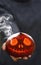 A Smoking pumpkin in a man`s hand. Big spooky helloween symbol. Selective focus