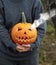 Smoking pumpkin in women`s hands. Big spooky helloween symbol. Selective focus