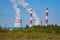 The smoky chimneys of the power plant stand against the blue sky