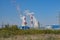 The smoky chimneys of the power plant stand against the blue sky