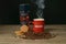 Smoky Coffee in Red Nescafe Mug With Raw Coffee Beans, Cookies, David off Coffee on a Table and Black Background