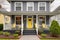 smoky gray colonial house with a vibrant yellow front door