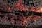 Smoldering embers of fire, live coals, burning charcoal in the background texture, closeup, glowing coal