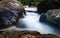 Smooth creek water flowing between the large rocks