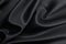 Smooth elegant black silk or satin texture as abstract background. Luxurious background design