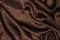 Smooth elegant brown silk or satin luxury cloth texture can be used as abstract background. Crumpled fabric Twisted at the side