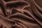 Smooth elegant brown silk or satin luxury cloth texture can be used as abstract background. Crumpled fabric Twisted at the side