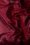 Smooth elegant burgundy chiffon fabric abstract background. Dark red wine silk luxury cloth texture light surface design