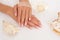 Smooth female hands holding a seashell, showing the beauty of manicure.