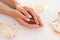 Smooth female hands holding a seashell, showing the beauty of manicure.