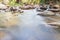 Smooth flowing water through the natural rock creek.