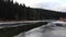 Smooth flyover above frozen mountain river in that runs between the mountains, zoom in. Carpathians.