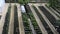 Smooth long beds with vegetables, berries and shrubs in the country in summer and spring. Greenhouses top view. Garden beds near