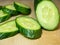 A smooth, medium-sized cucumber cut into slices. Cucumber on a cutting board. Vegetable isolate. Fresh ripe vegetable