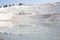 Smooth mirror reflective surface of water in thermal bath travertine terrace Pamukkale mountain in Turkey.