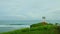 smooth panorama from blue ocean with strong waves to white gazebo on green hill